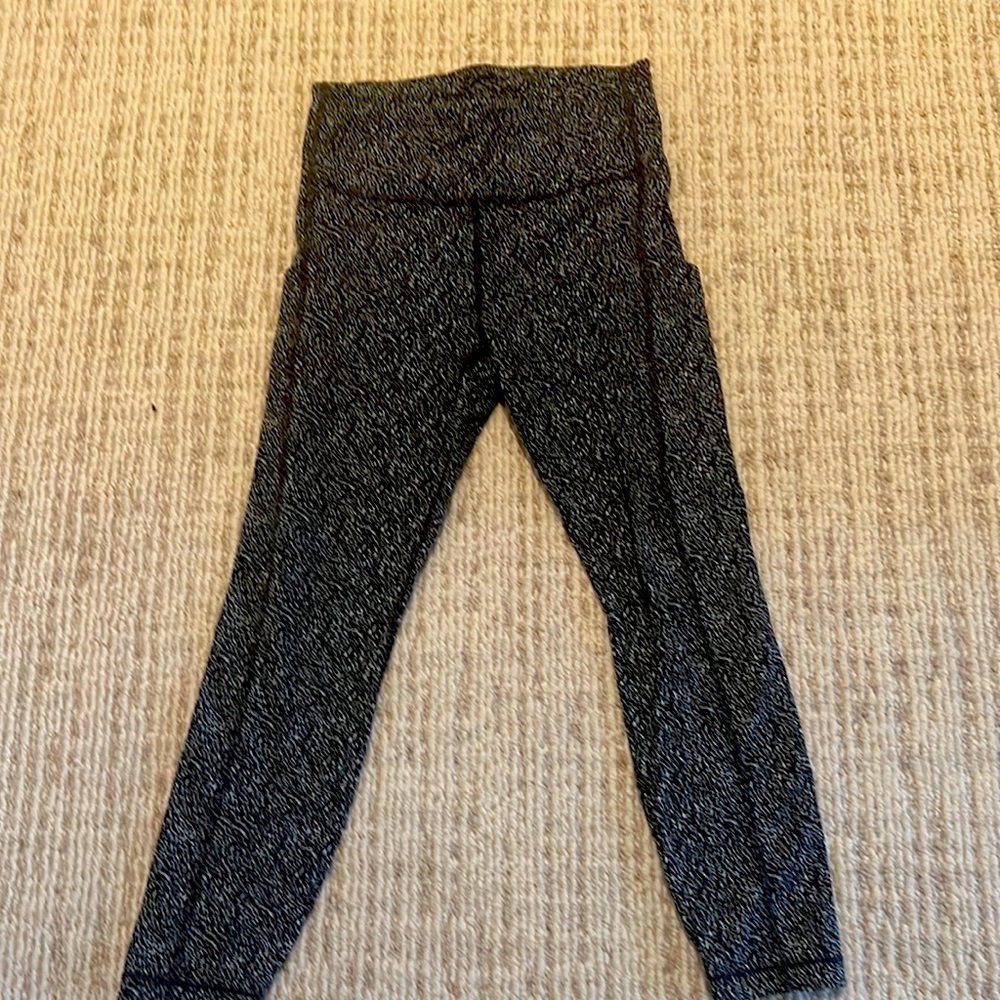 Athleta ultimate stash texture 7/8 tight.  Black background w white design.